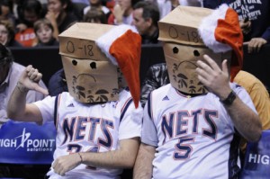 Unidentified New Jersey Nets fans react during the fourth quarter of an NBA basketball game against the Dallas Mavericks, Wednesday, Dec. 2, 2009, in East Rutherford, N.J. The Nets are 0-18 as the Mavericks won 117-101. (AP Photo/Bill Kostroun)